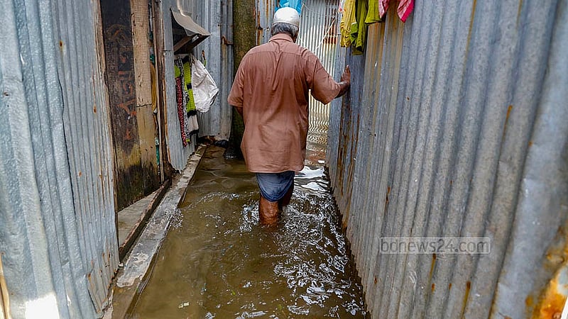 A senior citizen wades through knee-deep water in the Jungle Bari neighbourhood of Matuail in Dhaka’s Jatrabari after rain triggered by Cyclone Remal. Photo: Mahmud Zaman Ovi