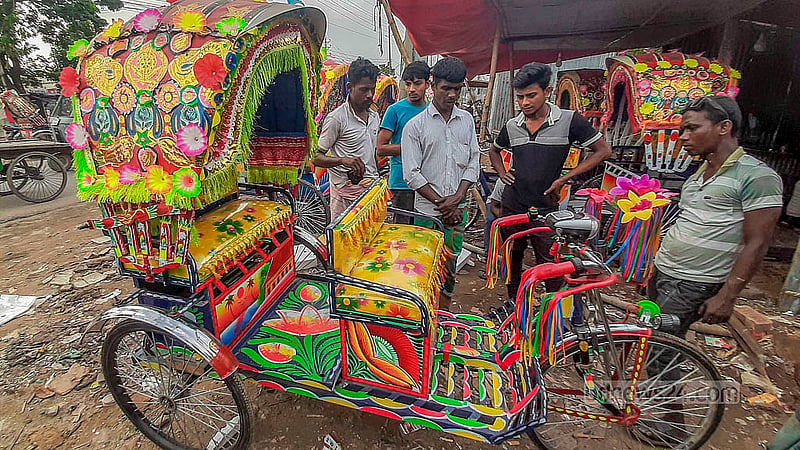 Customers browse battery-run rickshaws at a workshop in Dhaka’s Rayerbazar.