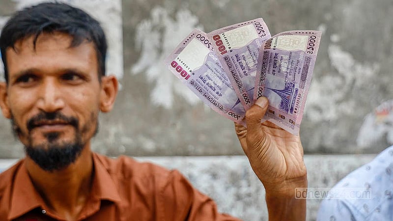 As Eid approaches, shops exchanging old and torn currency notes turn into bustling trading markets for fresh banknotes. People throng these sidewalk stalls to collect new notes for Eidi. This year, the shops are buzzing with new notes without the image of Bangabandhu Sheikh Mujibur Rahman given by Bangladesh Bank. Photo: Mahmud Zaman Ovi