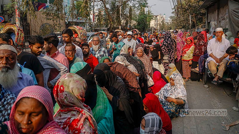 People queue to buy products from Trading Corporation of Bangladesh (TCB) trucks in the blazing sun on Wednesday, Feb 18, 2026, near the Town Hall in Dhaka’s Mohammadpur. Photo: Mahmud Zaman Ovi