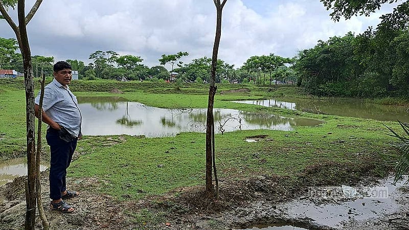 Encroachers have excavated soil from the centre of Kalachanpara’s cremation site. Village head Aung Cho Chan Talukder shows the damage.