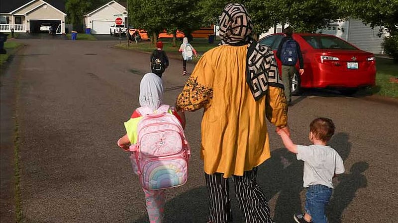 Wahida Habibi, Afghan refugee mother, walks with her children to the school bus in Bowling Green, Kentucky, US, April 30, 2025. REUTERS