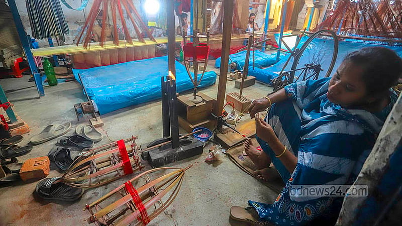 A worker is diligently winding thread, preparing it for the weaving process at Benarasi Palli in Dhaka’s Mirpur. Photo: Abdullah al Momin