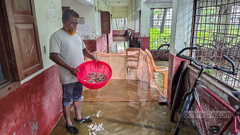 An employee fishes using mosquito nets on the balcony of Kazi Nazrul Islam Hall at Comilla Victoria Government College, which has been flooded after heavy rain. Photo: Tanvir Dipu