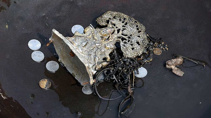 Items collected by people, who go to the river to hunt for coins and other valuables from the waters of river Yamuna, are kept in a container in New Delhi, India, Jun 26, 2025. REUTERS