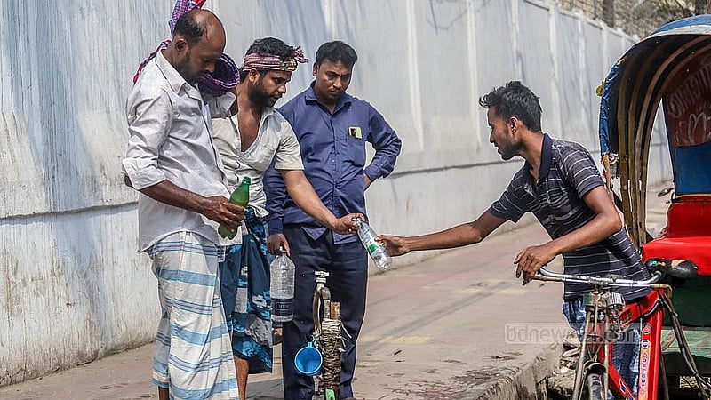 Many fill up their bottles with water to quench their thirst in the intense heat at Bangabhaban Colony in Tikatuli on Sunday, Apr 6, 2025.  Photo: Abdullah al Momin