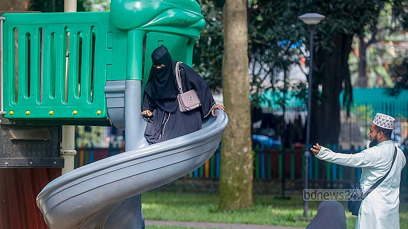 A young woman climbs a slide at the children’s corner in Dhaka’s Ramna Park, despite a notice at the entrance prohibiting adults from using the playground equipment. Photo: Mahmud Zaman Ovi