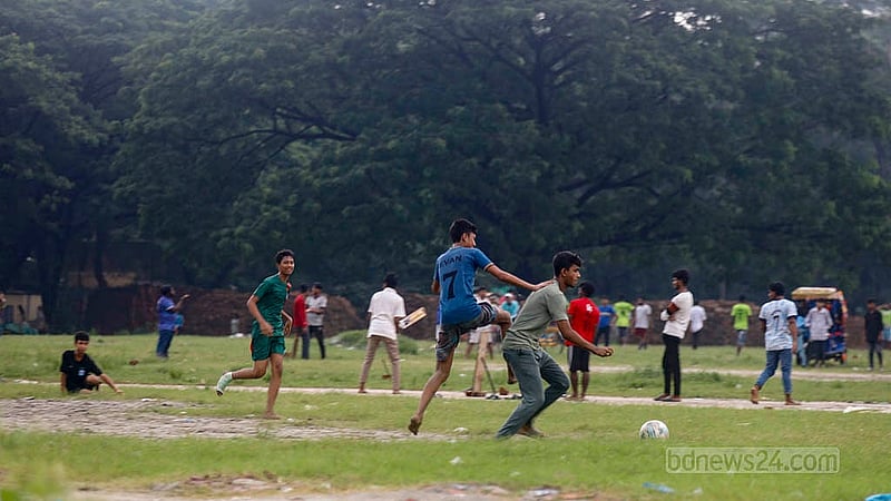 Though the research field of Sher-e-Bangla Agricultural University remains empty, a signboard on one side reads “Access Restricted”. Yet, children and teenagers gather there to play and exercise every afternoon. Photo: Mahmud Zaman Ovi