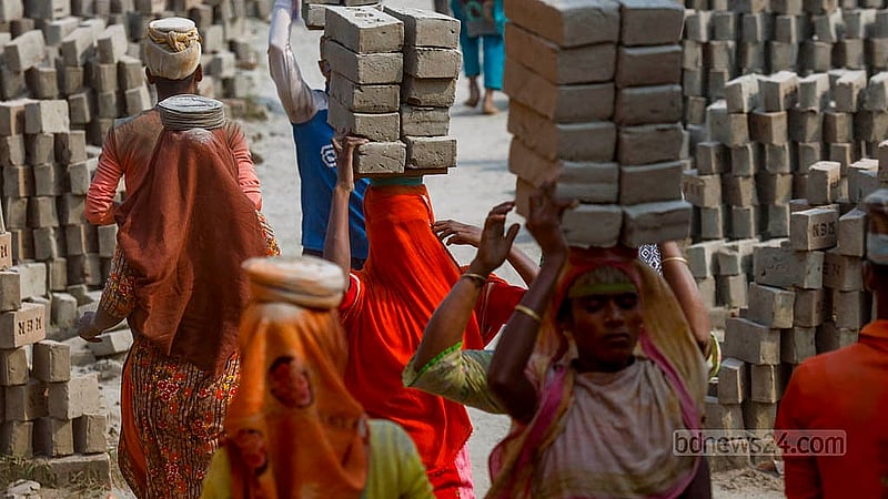 Women carry 10 raw bricks at a time to the kiln for firing, balancing them on gamchha, or local towels, placed on a piece of wood. Photo: Mahmud Zaman Ovi
