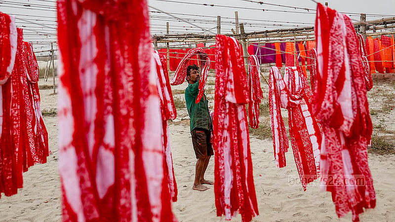 A worker dries freshly dyed batik fabric in an open area of Banti village in Narayanganj's Araihazar. Weak winter sunlight has made the drying process more difficult. Photo: Mahmud Zaman Ovi