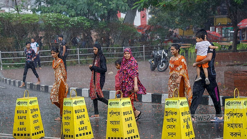 The rain drenches pedestrians and families walking through Dhaka’s Hatirjheel on Thursday, May 1, 2025. Photo: Mahmud Zaman Ovi