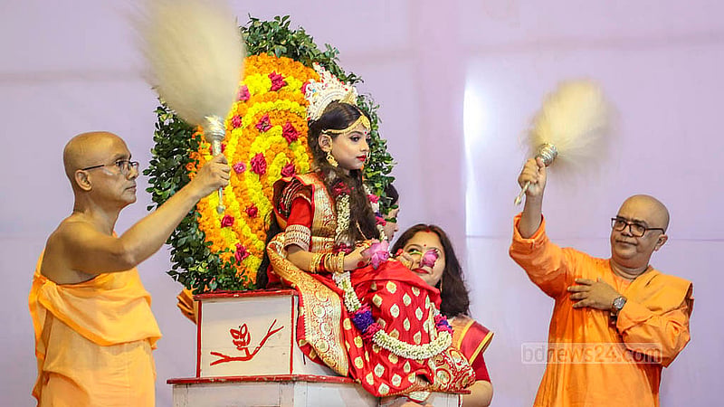 A priest fans Sanghita Bhattacharya, a girl who was symbolically worshipped as the Goddess Durga during the Kumari Puja at Dhaka’s Ramakrishna Mission on Friday, Oct 11, 2024. Photo: Abdullah al Momin