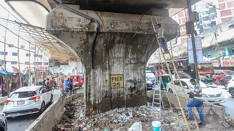 Posters and leaflets are peeled off the pillars at the Jatrabari-Gulistan Flyover as part of the revamping efforts. Photo: Abdullah Al Momin