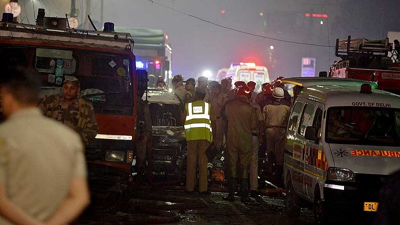 Police and firefighters stand guard at the site of an explosion in the old quarters of Delhi, India, Nov 10, 2025. REUTERS/Stringer