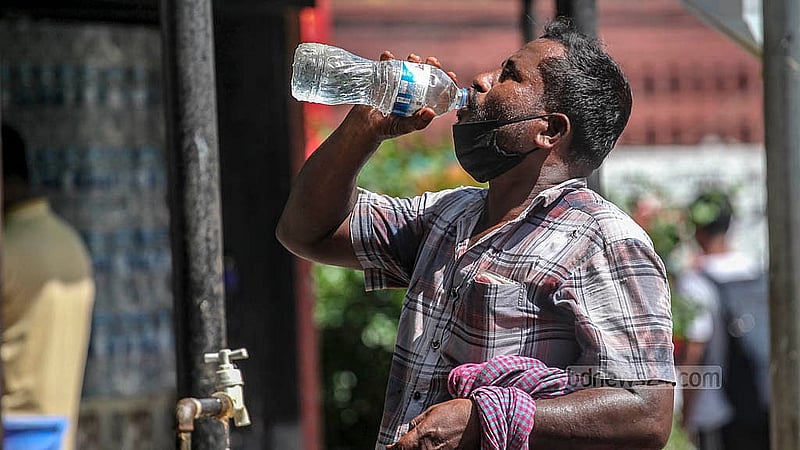 Rickshaw pullers fill bottles with water and drink amid the heat, in front of the Aparajeyo Bangla sculpture at Dhaka University on Monday, Aug 11, 2025. Photo: Abdullah al Momin