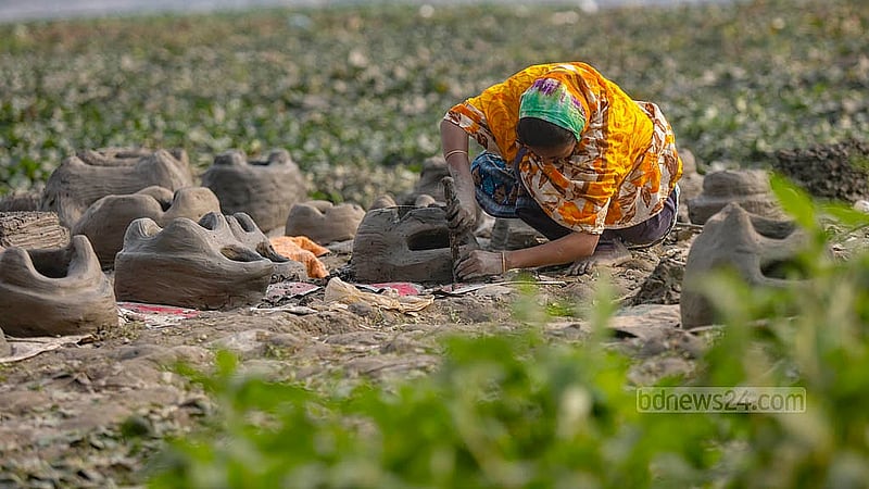 A woman works on shaping clay stoves along the riverbank in front of Kamrangirchar Government Secondary School. From morning to afternoon, she can make up to four stoves in a day. Photo: Mahmud Zaman Ovi