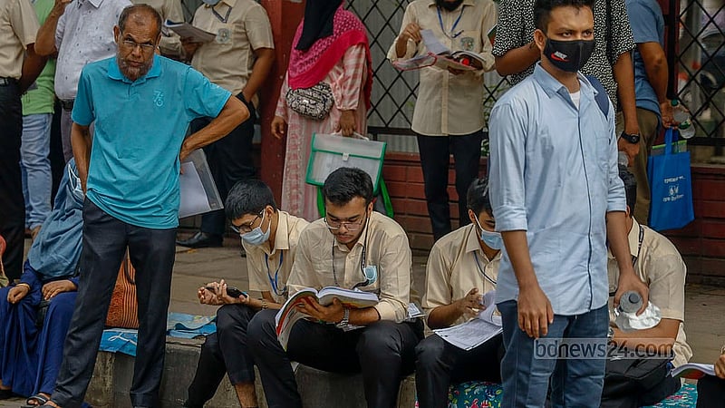 Just before the start of the exam, a student glances through a textbook outside the Siddeshwari Girls’ College centre. Photo: Mahmud Zaman Ovi