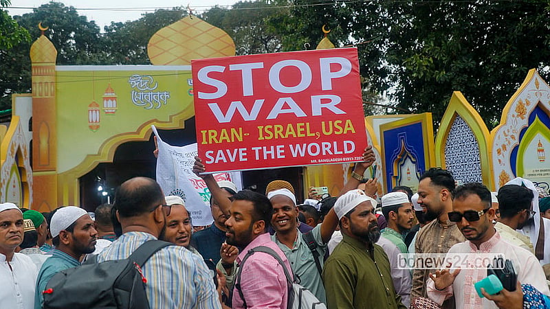 A person holds up a placard demanding an end to the Iran war after the Eid-ul-Fitr prayers at the National Eidgah on Saturday morning. Photo: Abdullah al Momin