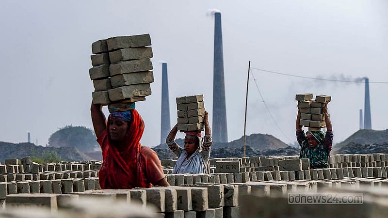 Women work at a brick kiln in Jajira of Dhaka's Keraniganj, where bricks burning in the kiln behind them. Photo: Mahmud Zaman Ovi
