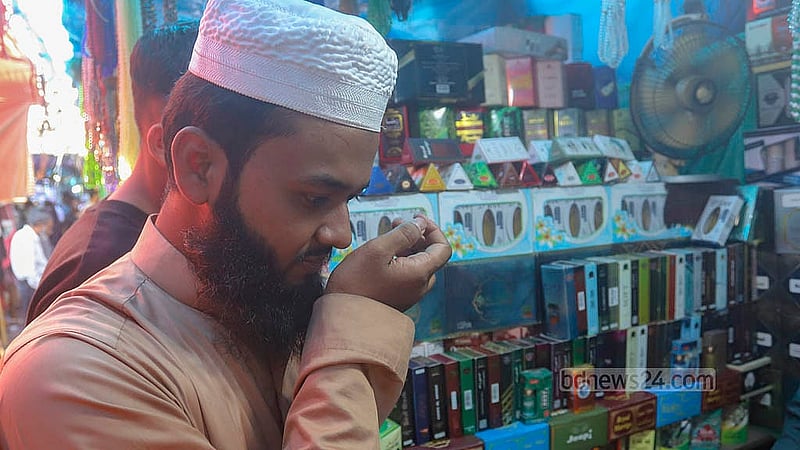 A shopper buys attar from a shop in front of the Baitul Mukarram Mosque ahead of Eid ul-Fitr. Photo: Abdullah al Momin