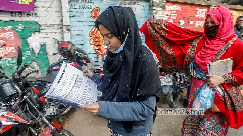 A candidate reads a book while walking to the exam venue for the Dhaka University Faculty of Science admission test for the 2025–26 academic year. Photo: Abdullah Al Momin