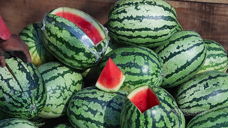 Traders slice open watermelons in the hope of attracting buyers. This photo was taken in the capital’s Sadarghat area. Photo: Abdullah al Momin