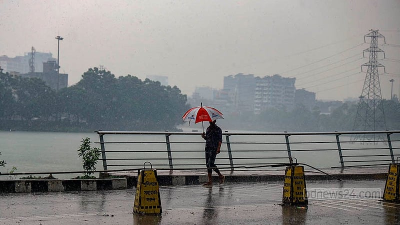 Many pedestrians carry umbrellas as they walk through Dhaka’s Hatirjheel during a shower on Thursday, May 1, 2025. Photo: Mahmud Zaman Ovi