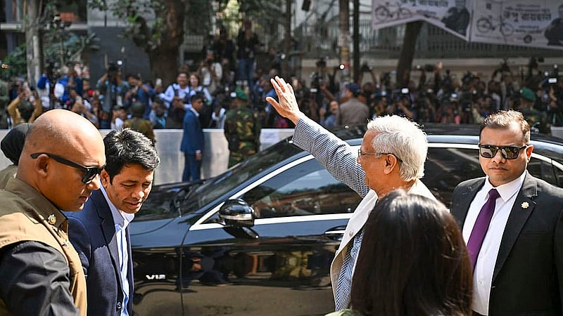 Following his vote, Muhammad Yunus waves to voters gathered outside the Gulshan Model School and College polling centre. Photo: PID