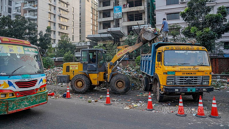 Waste dumped on Pragati Sarani is being loaded onto a DNCC truck with an excavator. Photo: Mahmud Zaman Ovi