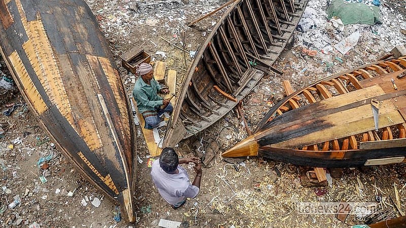 Workers carry out repairs on boats along the riverbank at Keraniganj’s Telghat. Photo: Abdullah Al Momin