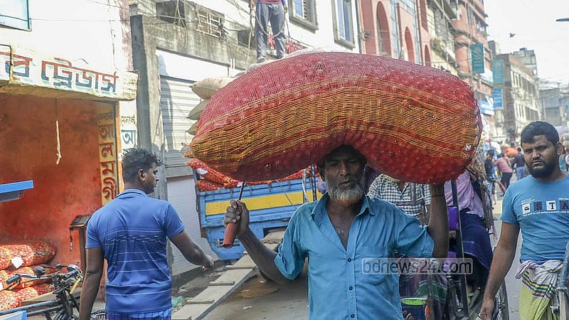 Workers are busy handling onions at a wholesale warehouse in Farashganj, Dhaka. Photo: Abdullah al Momin