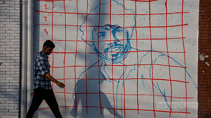 A portrait of Osman Hadi has been painted within small grids on a white wall at Old Dhaka’s Hazaribagh Tannery intersection. Photo: Mahmud Zaman Ovi