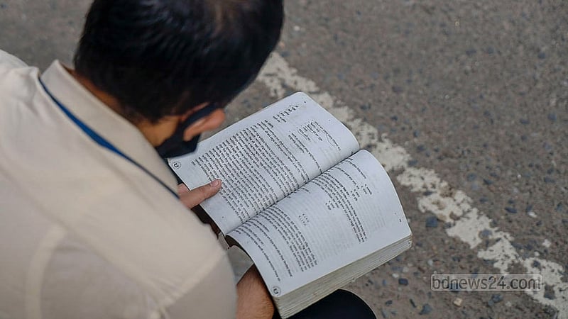 Just before the start of the exam, a student glances through a textbook outside the Siddeshwari Girls’ College centre. Photo: Mahmud Zaman Ovi