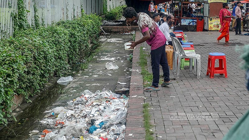 Discarded food packets, plastic bottles, and other waste from the stalls litter the pavement of Manik Mia Avenue, where they rot and release a stench across the area.Photo: Abdullah Al Momin