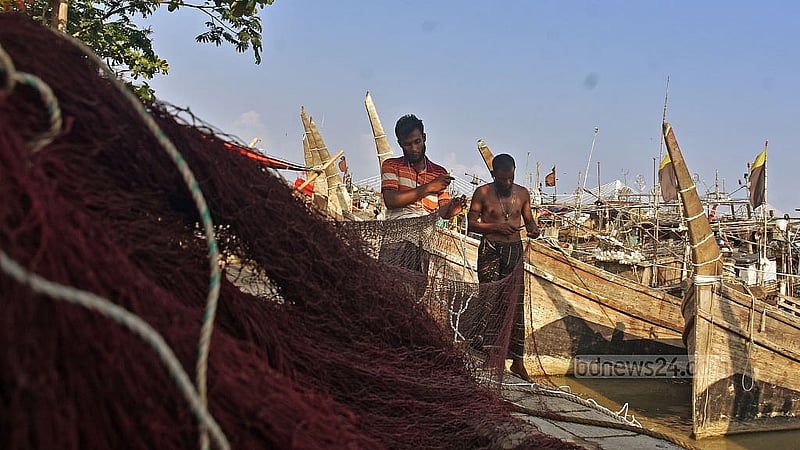 Fishermen repair nets in Chattogram’s Fisheryghat area during a ban on marine fishing. Photo: Suman Babu