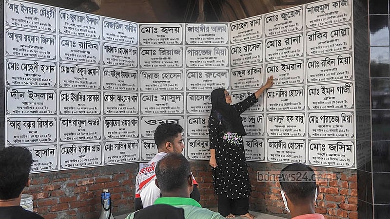 Mohammad Imran died in the Kajla area of Dhaka’s Jatrabari during the Anti-discrimination Student Movement on Jul 18. His sister Sanjida Islam showing her brother's name on the monument built in Jatrabari. Photo: Abdullah al Momin