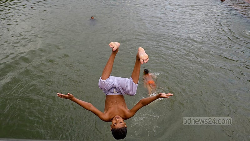 Children jump off the bridge at the lake in Zia Udyan for a swim. Even a few days ago, the lake was quite dry. Photo Mahmud Zaman Ovi