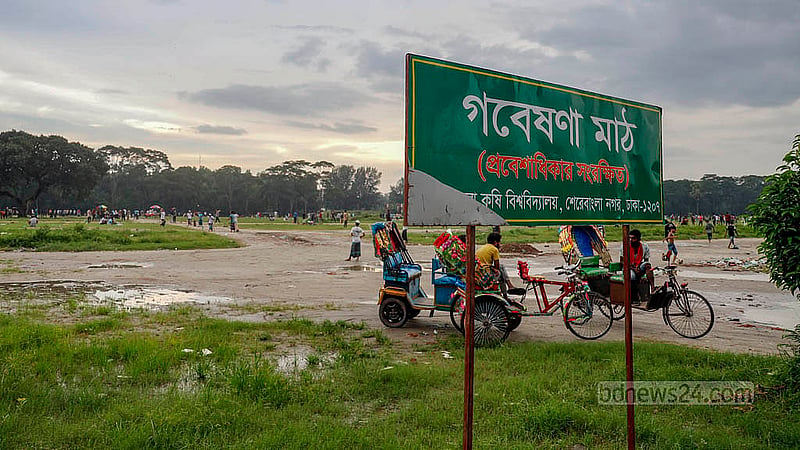 A signboard in front of Dhaka’s old trade fair ground now reads “Research Field -- Entry Restricted”. However, some of the young men playing there said they had not noticed the signboard a few months ago. Photo: Mahmud Zaman Ovi