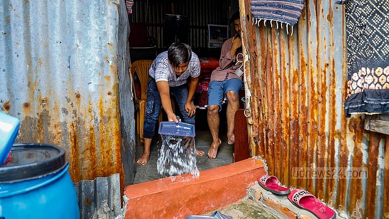 A young man uses a shovel to remove water from their partially submerged house at Matuail Uttorpara in Dhaka’s Jatrabari after rain under the influence of Cyclone Remal. Photo: Mahmud Zaman Ovi