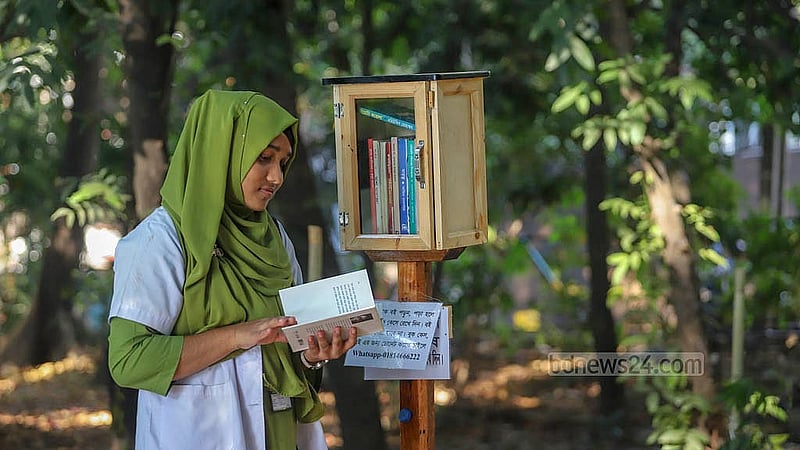 A visitor browses through a bookcase near Dhanmondi Lake. Photo: Abdullah al Momin