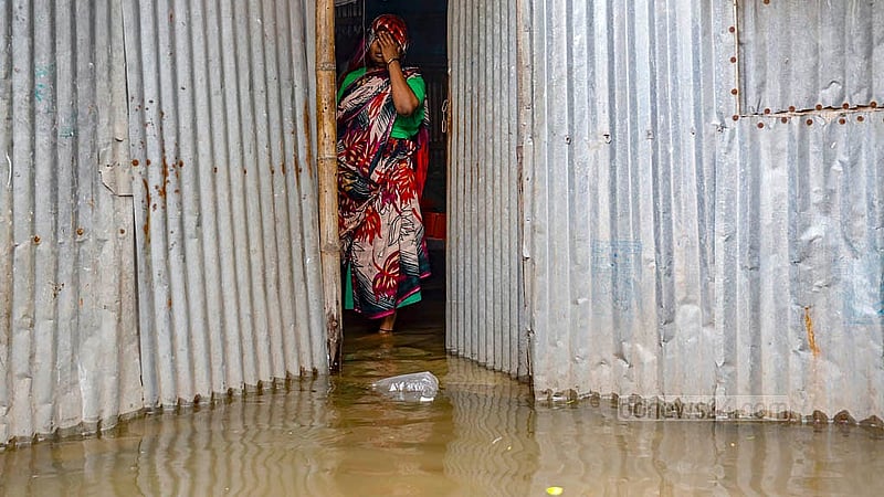 A woman stands in front of her partially submerged house at Matuail Jungle Bari in Dhaka’s Jatrabari after rain under the influence of Cyclone Remal. Photo: Mahmud Zaman Ovi