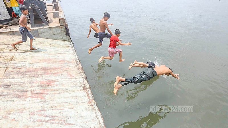 Children and teenagers dive into the Buriganga River, seeking some relief from the sweltering early autumn heat. Photo: Abdullah al Momin
