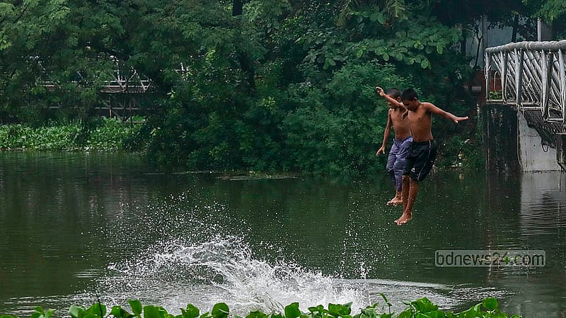 Children are seen splashing in the clean water of Dhanmondi Lake, enjoying a swim in the recently risen water. Photo: Mahmud Zaman Ovi