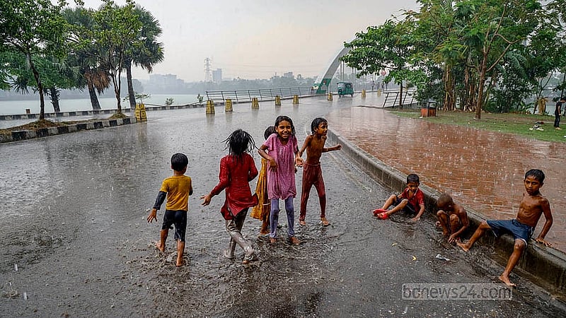 Sudden clouds darkened the skies before a shower cut through the heat in Dhaka’s Hatirjheel on Thursday, May 1, 2025.  Children took the opportunity to play in the rain. Photo: Mahmud Zaman Ovi