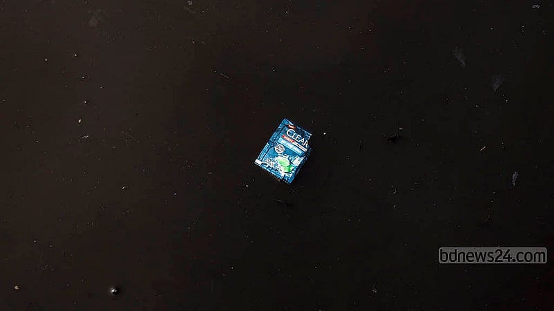 Waste materials float in the black water of the Buriganga River, looking like a painting done on black canvas. Photo: Mahmud Zaman Ovi
