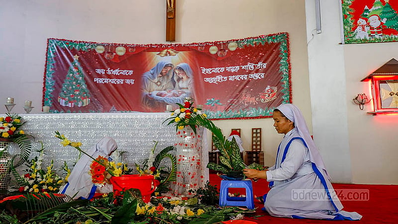 A sister decorates the prayer hall of Holy Rosary Church in Tejgaon with flowers on Christmas Eve. Photo: Mahmud Zaman Ovi