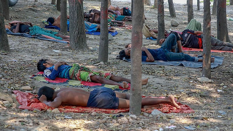 Labourers take naps in the shade to escape the heat of the summer afternoon in Dhaka’s Gabtoli. Photo: Muhammad Mostafigur Rahman