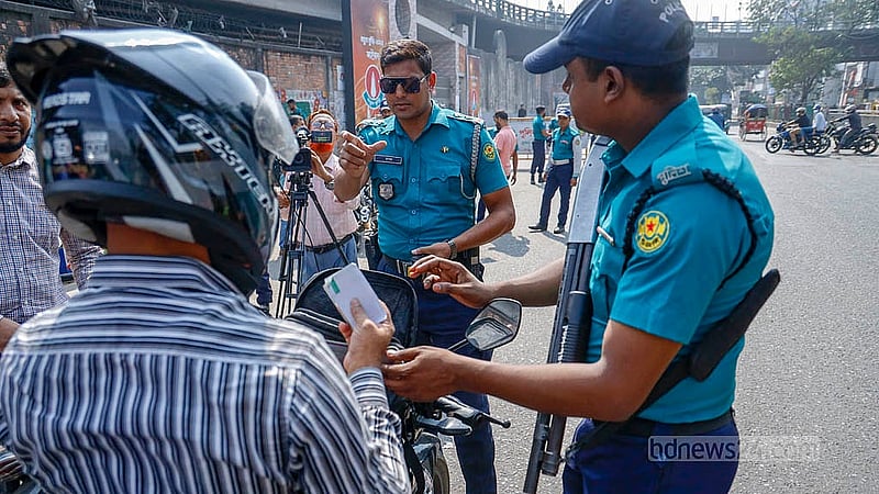 As part of the heightened security measures, police officers inspect motorcycle documents outside the TV Centre in Rampura on Wednesday, Nov 12, 2025. Photo: Mahmud Zaman Ovi