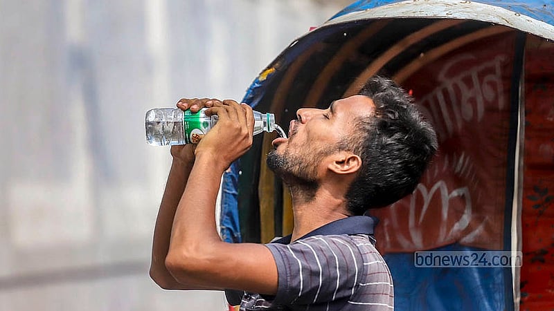 Day labourers suffer the most in the scorching heat. Rickshaw pullers fill up their bottles from a tap in front of Bangabhaban Colony in Tikatuli to quench their thirst on Sunday, Apr 6, 2025.  Photo: Abdullah al Momin