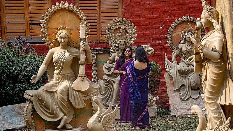 Visitors stop to take photographs with the idols being made outside the Gobinda Chandra Dev Building at Jagannath Hall. Photo: Mahmud Zaman Ovi
